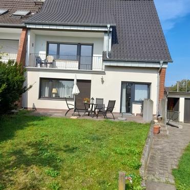 Zweist&ouml;ckiges Wohnhaus mit Balkon, Terrasse und gepflegtem gr&uuml;nen Vorgarten.